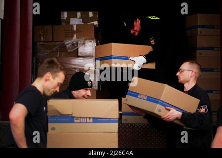 Les gardes chargent les fournitures d'aide prêtes pour un bus appartenant au volontaire britannique Cliff Wilson qui le transportera de Przemysl en Pologne à l'Ukraine et, à son retour, ramasse les femmes et les enfants ukrainiens et les ramentera à la frontière pour les mettre en sécurité en Pologne. Date de la photo: Mercredi 30 mars 2022. Banque D'Images