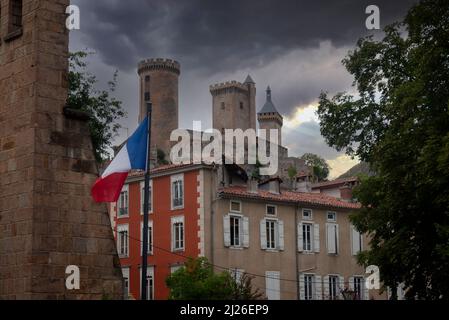 Vue sur les tours du château médiéval et le drapeau français volant dans la ville de Foix, capitale du département de l'Ariège dans le sud-ouest de la France Banque D'Images