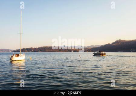 Vue panoramique d'un bateau et d'un voilier dans le lac Orta, Italie, au coucher du soleil. Copier l'espace. Banque D'Images