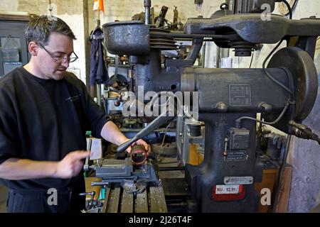 23 mars 2022, Saxe-Anhalt, Staßfurt: Alexander Koch travaille sur une fraiseuse dans l'atelier de Eisenbahnfreunde Traditionsbahnbetriebswerk Stassfurt e.V. de la cabine sur une locomotive à vapeur à une exposition de véhicules routiers historiques, le club offre une variété pour les fans du chemin de fer. Photo: Peter Gercke/dpa-Zentralbild/ZB Banque D'Images