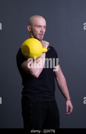 Guy avec un jaune kettlebell gym homme jaune anonyme, dans l'après-midi effort d'ajustement pour l'entraînement et plancher sportive, sud-est philippin. Courbe saine Banque D'Images