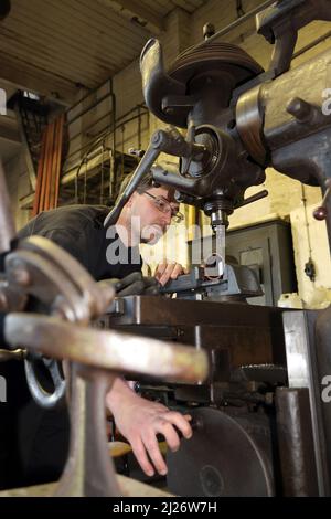 23 mars 2022, Saxe-Anhalt, Staßfurt: Alexander Koch travaille sur une fraiseuse dans l'atelier de Eisenbahnfreunde Traditionsbahnbetriebswerk Stassfurt e.V.. Du trajet en taxi sur une locomotive à vapeur à une exposition de véhicules routiers historiques, le club offre une variété de services aux fans du chemin de fer. Photo: Peter Gercke/dpa-Zentralbild/ZB Banque D'Images