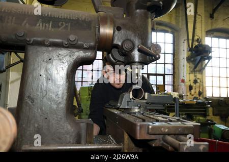 23 mars 2022, Saxe-Anhalt, Staßfurt: Alexander Koch travaille sur une fraiseuse dans l'atelier de Eisenbahnfreunde Traditionsbahnbetriebswerk Stassfurt e.V.. Du trajet en taxi sur une locomotive à vapeur à une exposition de véhicules routiers historiques, le club offre une variété de services aux fans du chemin de fer. Photo: Peter Gercke/dpa-Zentralbild/ZB Banque D'Images