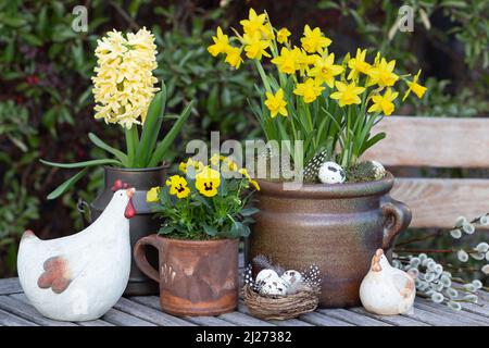 décoration de pâques avec fleurs de printemps jaunes dans des pots rustiques et des poules de pâques Banque D'Images