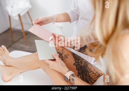 Esthéticienne donnant des cartes en papier à la femme dans le salon de beauté Banque D'Images