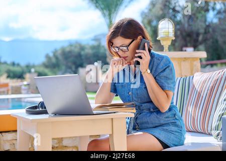Femme d'affaires d'âge moyen utilisant un ordinateur portable à l'extérieur. Banque D'Images