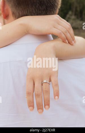 Une photo d'un couple qui s'embrasse avec un anneau de diamant sur le doigt de la fille Banque D'Images