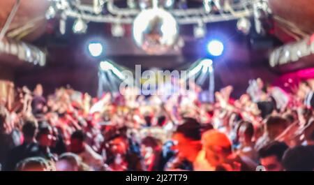 Des gens flous dansant lors d'un concert de musique - Abstract fond défoqué de discothèque après la fête au festival de scène - Nightlife divertissement Banque D'Images