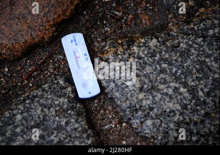 Hambourg, Allemagne. 30th mars 2022. Un test négatif de Corona se situe entre les pavés sur le sol mouillé. Credit: Jonas Walzberg/dpa/Alay Live News Banque D'Images