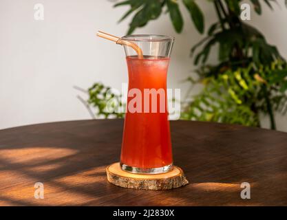 verre rafraîchissant de limonade à la framboise avec paille isolée sur table en bois vue latérale Banque D'Images