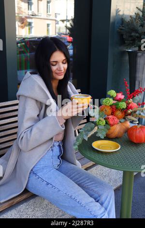 Belle jeune femme ukrainienne qui boit un cappuccino et souriait dans un café. Banque D'Images