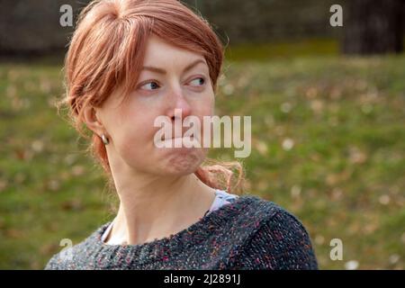 Expression faciale d'une jeune femme européenne à cheveux rouges Banque D'Images