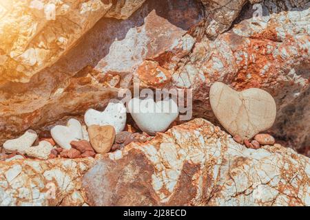 Galets en forme de cœur sur fond de roche de lave luxuriante. Cadre romantique, concept de la Saint-Valentin. Banque D'Images