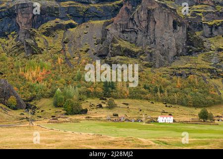 Maison de ferme et maisons en gazon près d'une montagne de lave avec des couleurs d'automne dans le sud de l'Islande. Banque D'Images