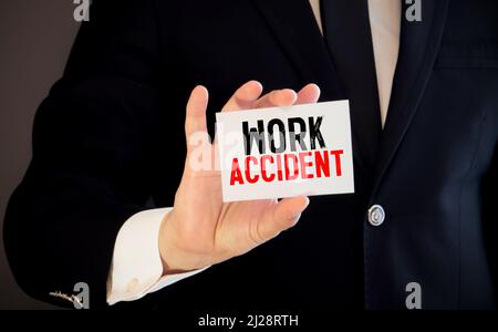 Médecin tenant une carte avec texte accident de travail, concept médical. Banque D'Images