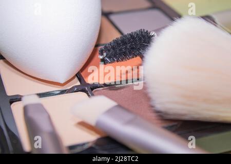 Un sac à maquillage rose avec des produits cosmétiques de beauté qui se répande sur un fond de couleur pastel, avec un espace vide sur le côté Banque D'Images