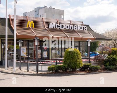 Restaurant McDonald's dans un quartier urbain près des appartements résidentiels, le détail de la façade de bâtiment de McDonalds vue frontale, terrain vide, ville vie Cracovie Pologne Banque D'Images
