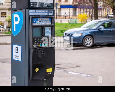 Parking compteur de billets dans la rue et une voiture à proximité, frais de stationnement extérieur pour véhicules urbains, concept de zones de stationnement de la ville, personne. Cracovie Banque D'Images