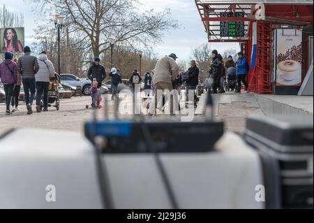 Un musicien de rue recueille des documents en face d'un centre commercial. Un homme mature avec un violon électronique. Les passants écoutent la pièce du musicien. Vue de behin Banque D'Images