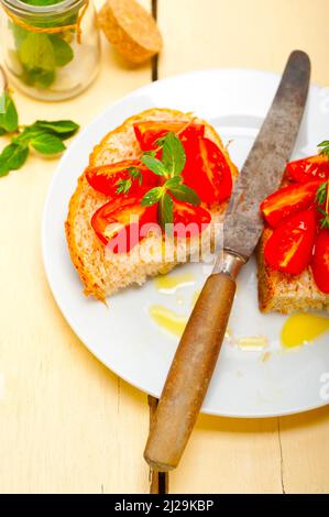 Bruschetta aux tomates italiennes avec le thym et les feuilles de menthe Banque D'Images