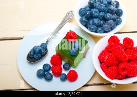Gâteau à la mousse de matcha au thé vert avec framboises et bleuets sur le dessus Banque D'Images