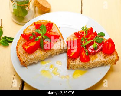 Bruschetta aux tomates italiennes avec le thym et les feuilles de menthe Banque D'Images