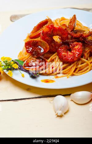 Fruits de mer pâtes spaghetti italien sauce tomate rouge sur blanc sur la table de bois rustique Banque D'Images
