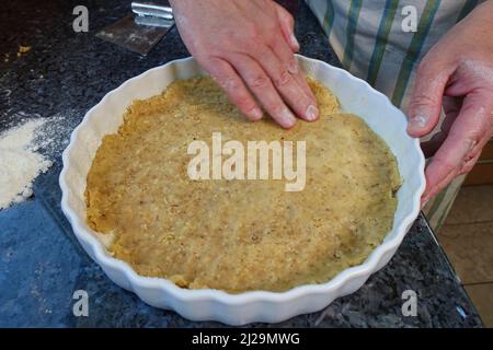 Cuisine du sud de l'Allemagne, pâtisserie, préparation de gâteau aux légumes copieux à base de noix, pressage de la pâte de noix dans le moule à pâtisserie, moule à tarte, moule à quiche Banque D'Images