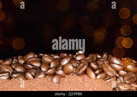 Café Arabica, grains de café couchés sur du café moulu, arrière-plan abstrait Banque D'Images