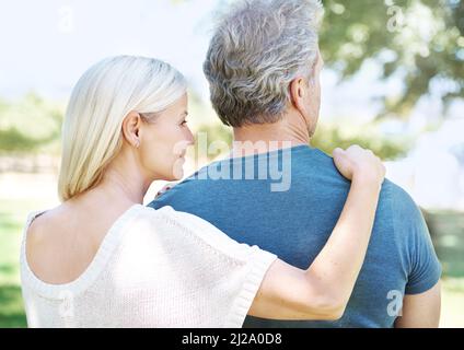 Soutien et amour. Vue arrière d'un couple mature qui s'éloigne en se tenant debout à l'extérieur. Banque D'Images