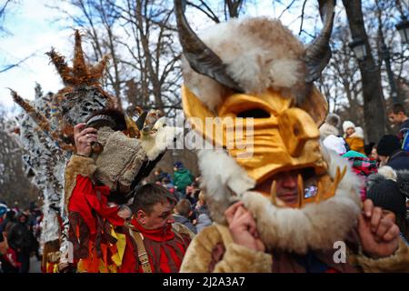 Sofia, Bulgarie - 9 janvier 2022 : des gens costumés, des danseurs masques appelés Kukeri, exécutent une danse traditionnelle pendant le Festival Surva pour repousser le mal Banque D'Images