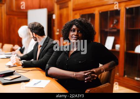 Portrait d'une femme d'affaires confiante aux mains clastées dans la salle du conseil d'administration pendant la réunion Banque D'Images