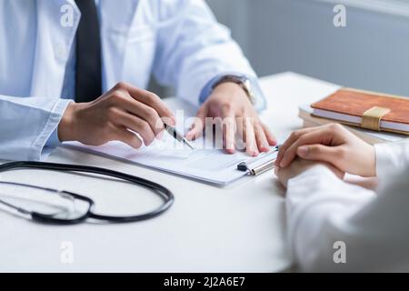 Médecin asiatique de sexe masculin examinant le patient à la clinique Banque D'Images