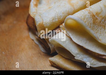 Gros plan de crêpes fraîchement cuites empilées sur une planche de bois Banque D'Images