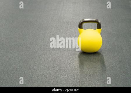 Exercice de fond de poids de kettlebell jaune, de sport d'entraînement pour lourd pour métal simple, fer dur. Texte coloré fitness, haltères physiques Banque D'Images