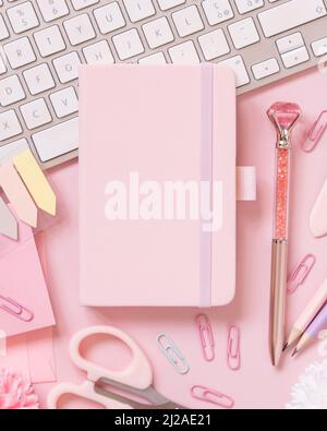 Ordinateur portable couverture rigide, accessoires scolaires rose et clavier rose clair, vue du dessus, maquette de manuel. Gilly Workplace avec bloc-notes, ciseaux, crayon, pe Banque D'Images