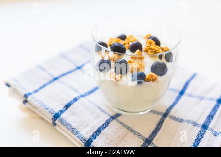 yaourt avec céréales et bleuets. Petit déjeuner sain et pauvre en calories. Bleuets sains avec yaourt naturel et flocons d'avoine Banque D'Images