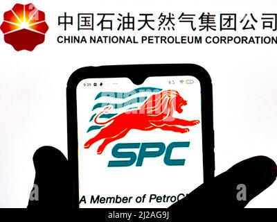 Dans cette illustration, le logo Singapore Petroleum Company Limited est affiché sur un écran de smartphone avec un logo China National Petroleum Corporation en arrière-plan Banque D'Images