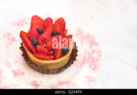 Tarte aux fruits maison avec fraise isolée sur table blanche, vue du dessus. Mise au point sélective. Banque D'Images