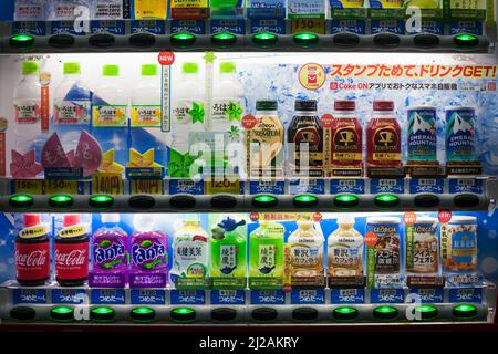 Vue panoramique horizontale sur un distributeur de sodas japonais lumineux et coloré la nuit Banque D'Images