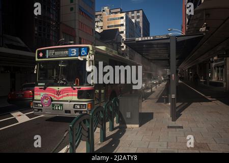 Vue horizontale d'un bus urbain à vapeur sur un arrêt de bus dans le centre-ville de Kyoto, Japon Banque D'Images