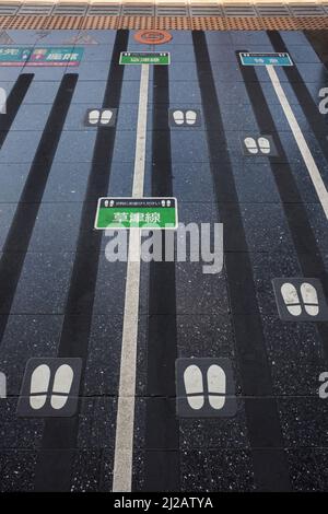 Vue verticale de l'étage empreintes des marques pour garder la commande des passagers dans une gare du centre-ville de Kyoto, au Japon Banque D'Images