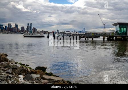 Port Imperial / Weehawken Ferry terminal à Hudson River, New Jersey avec ferry, vue latérale pendant la journée d'hiver nuageux, horizontal Banque D'Images