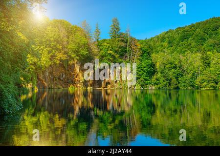 Soleil au bord du lac Galovac avec petite cascade dans le parc national des lacs de Plitvice de Croatie dans la région de Lika. Patrimoine mondial de l'UNESCO. Banque D'Images