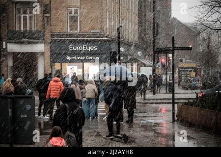 Les navetteurs se précipitent dans la neige et la pluie jusqu'à la gare centrale d'Aarhus, au Danemark. Banque D'Images