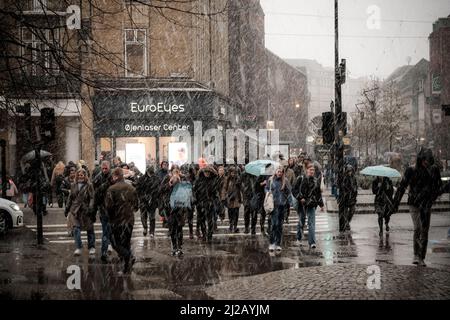 Les navetteurs se précipitent dans la neige et la pluie jusqu'à la gare centrale d'Aarhus, au Danemark. Banque D'Images