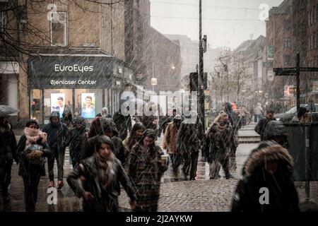 Les navetteurs se précipitent dans la neige et la pluie jusqu'à la gare centrale d'Aarhus, au Danemark. Banque D'Images