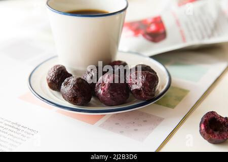 Cerises séchées avec une assiette en porcelaine Banque D'Images