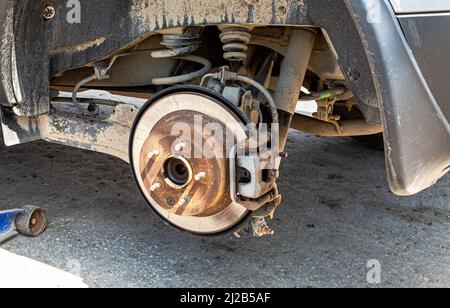 Disque de frein de voiture usé en gros plan. Réparation des freins d'une voiture. Remplacement des roues et des freins Banque D'Images