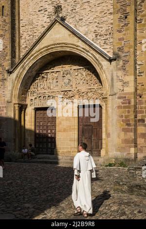Conques (sud de la France) : monk devant la porte de l'église abbatiale de Sainte-Foy, sur le chemin de Saint-Jacques (ou Camino de Saint-Jacques-de-Compostelle). Banque D'Images